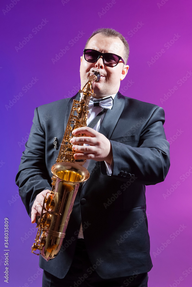 Fototapeta premium Musicians Concepts. Portrait of Mature Expressive Caucasian Saxophonist Against Colorful Background.