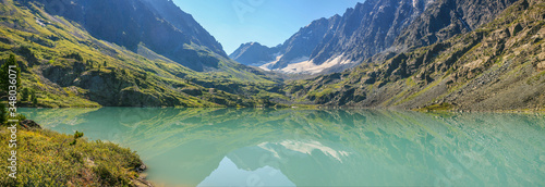 Picturesque lake in the mountains of Altai. Summer travel in the mountains, hiking.