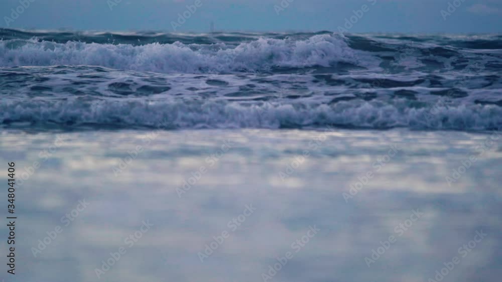 Waves rolling on the shore. White foam rising and disappearing as waves crash on the sandy beach. Waves rolling on the shore. White foam rising and disappearing as waves crash on the sandy beach.