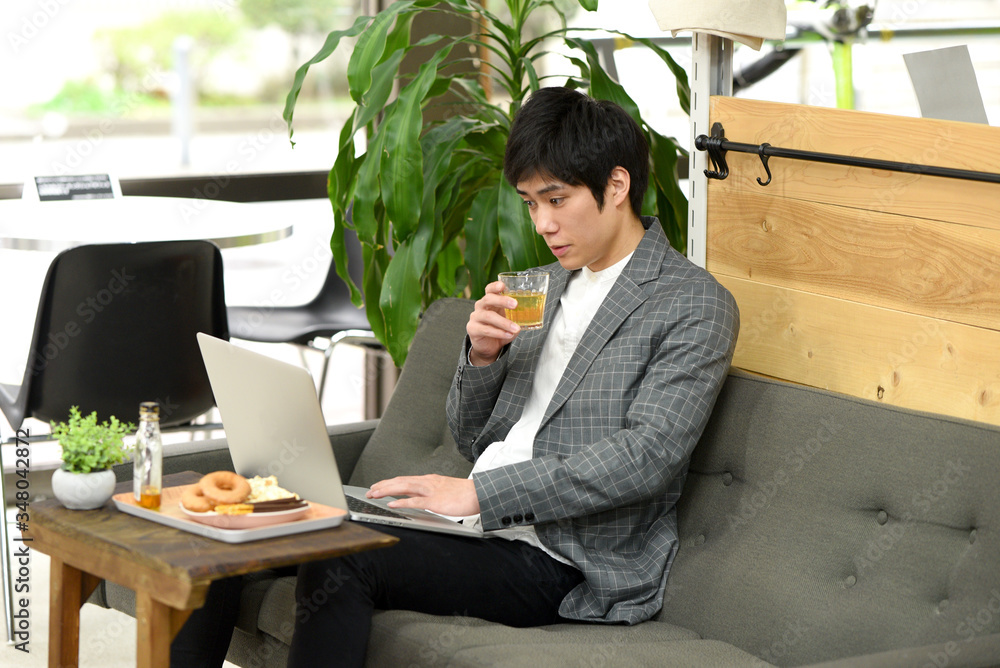 PCを見ながら飲む男性 PCを見ながら飲む男性