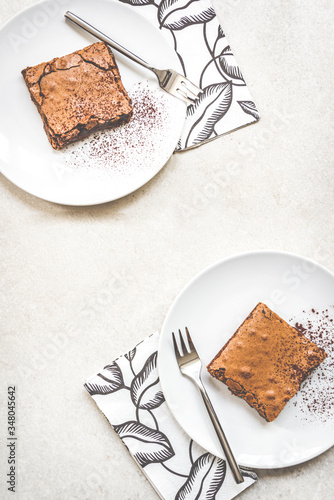 Obraz na płótnie Top view of two dessert plates with brownie cake over white rustic background. w salonie