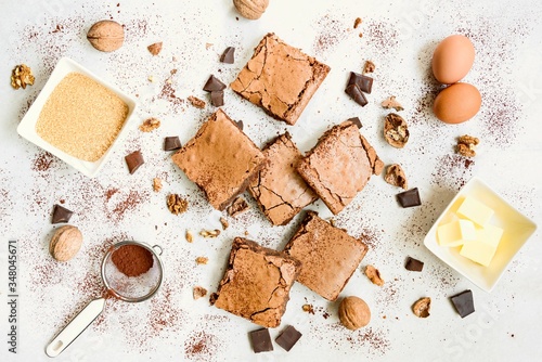 Obraz na płótnie Top view of freshly baked home made brownie cake arranged with recipe ingredients over white rustic background. w salonie