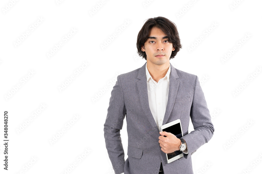 Isolated white background with clipping path of cool long hair young businessman in grey suit hold tablet in left hand. Concept for online business, e-commerce, information technology Isolated white background with clipping path of cool long hair young businessman in grey suit hold tablet in left hand. Concept for online business, e-commerce, information technology