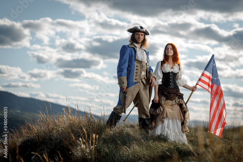 Bild auf Leinwand Man in form of officer of War of Independence and girl in historical dress of 18th century