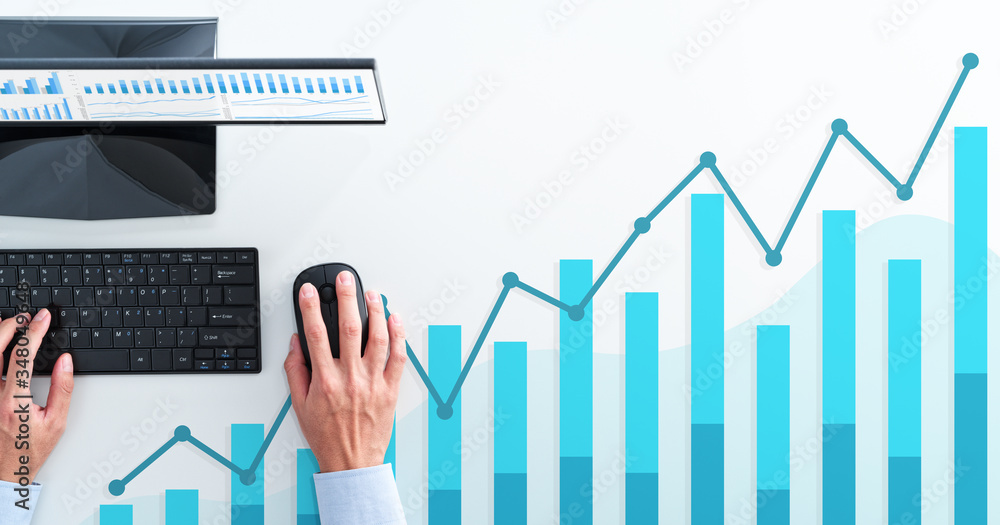 Business analysis and calculating. Top view of business man using spreadsheet. Blue graphs and desktop computer. Business analysis and calculating. Top view of business man using spreadsheet. Blue graphs and desktop computer.
