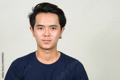 Portrait of young Asian man looking at camera