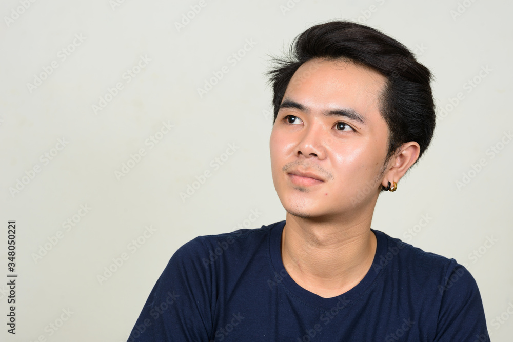 Portrait of young Asian man thinking and looking up