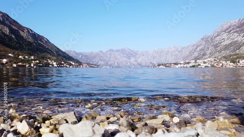Wallpaper Mural Rocky sea shore and Small and beautiful village in horizon with humongous mountain range in background. Suburbs of Kotor, Montenegro. Torontodigital.ca