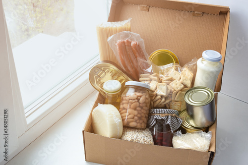 Fotografi Grocery set for needy in crisis, pasta, beans, canned food etc in cardboard box