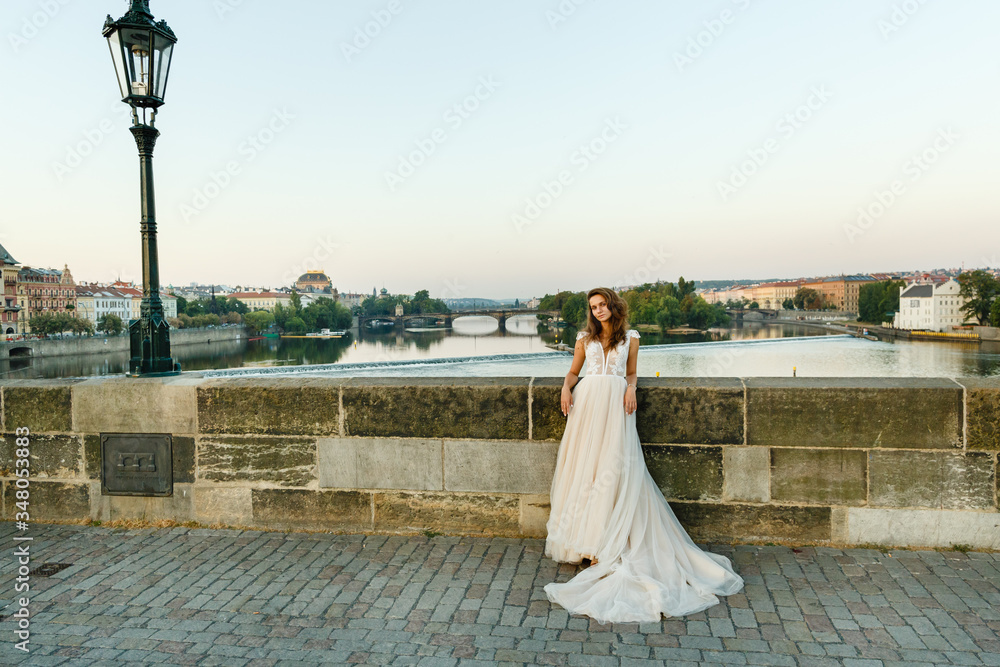 Obraz premium Young bride poses on Charles Bridge. Bride in prague
