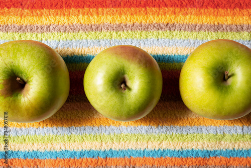 Apples on colored fluffy furry textyle background in blurred focus. Top view. Summer concept photo. photo