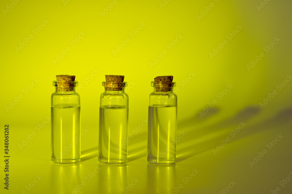 Three glass corked bottles filled with liquid. Background for science and medicine. Virus vaccine. Three glass corked bottles filled with liquid. Background for science and medicine. Virus vaccine.