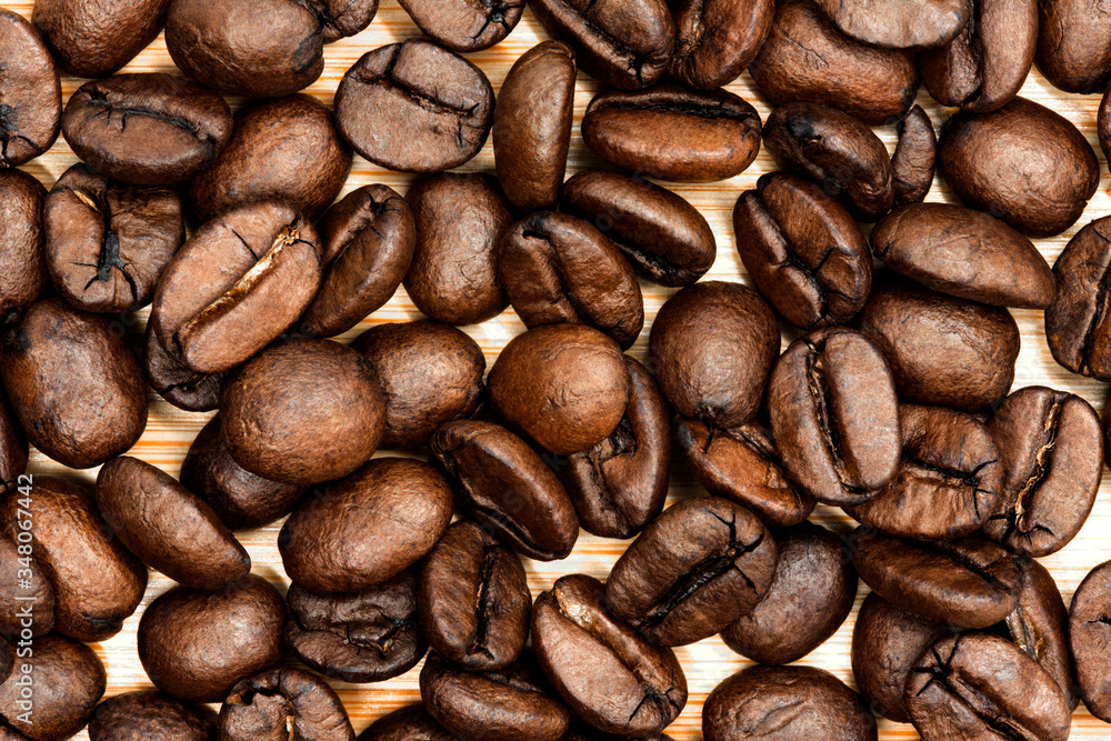 Naklejka premium Roasted coffee beans close up background 