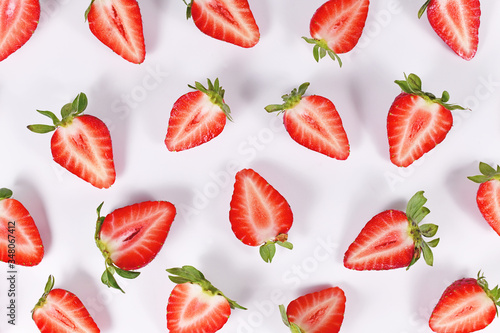 Top view of strawberry fruit halves arranged on white background