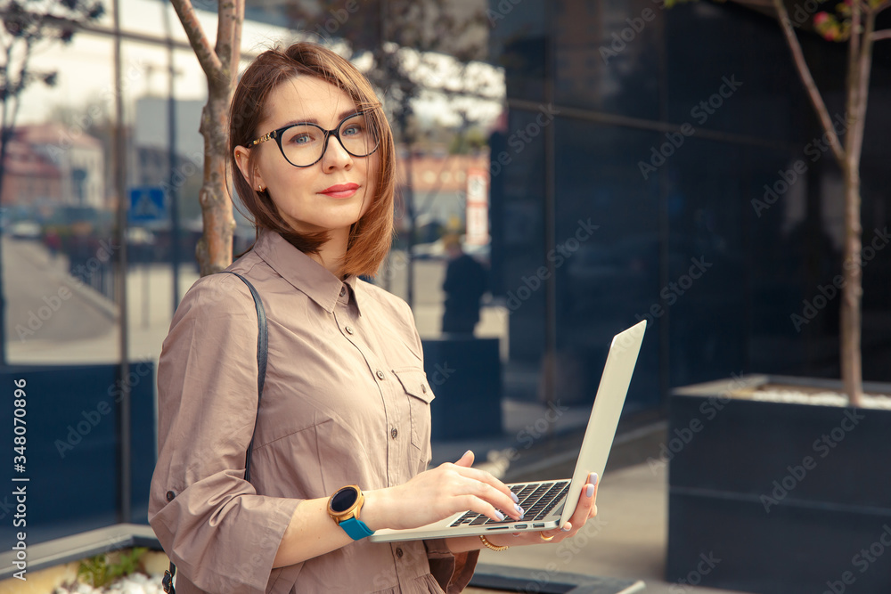 Business woman with computer on the background of a modern building. Business woman with computer on the background of a modern building.