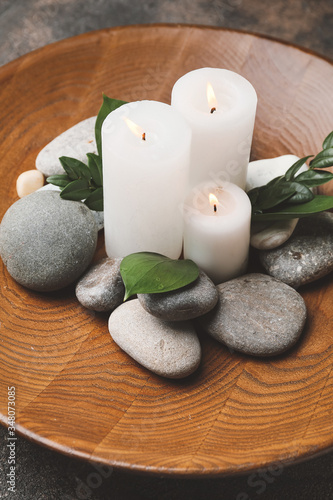 Beautiful candles and spa stones on plate