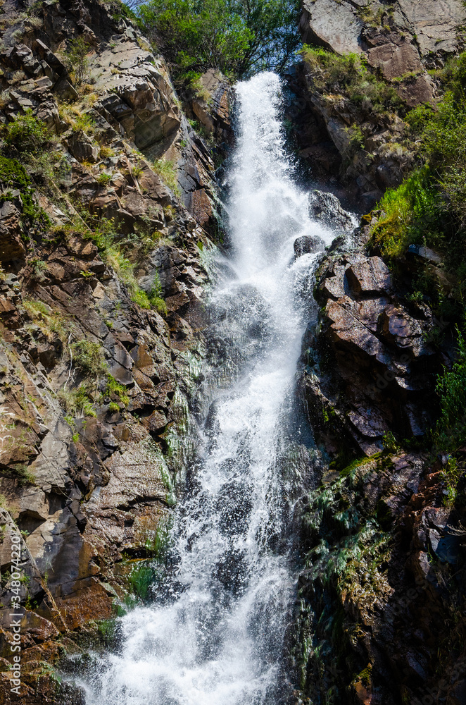 Fototapeta premium Rocky mountains waterfall in the afternoon short exposure flash