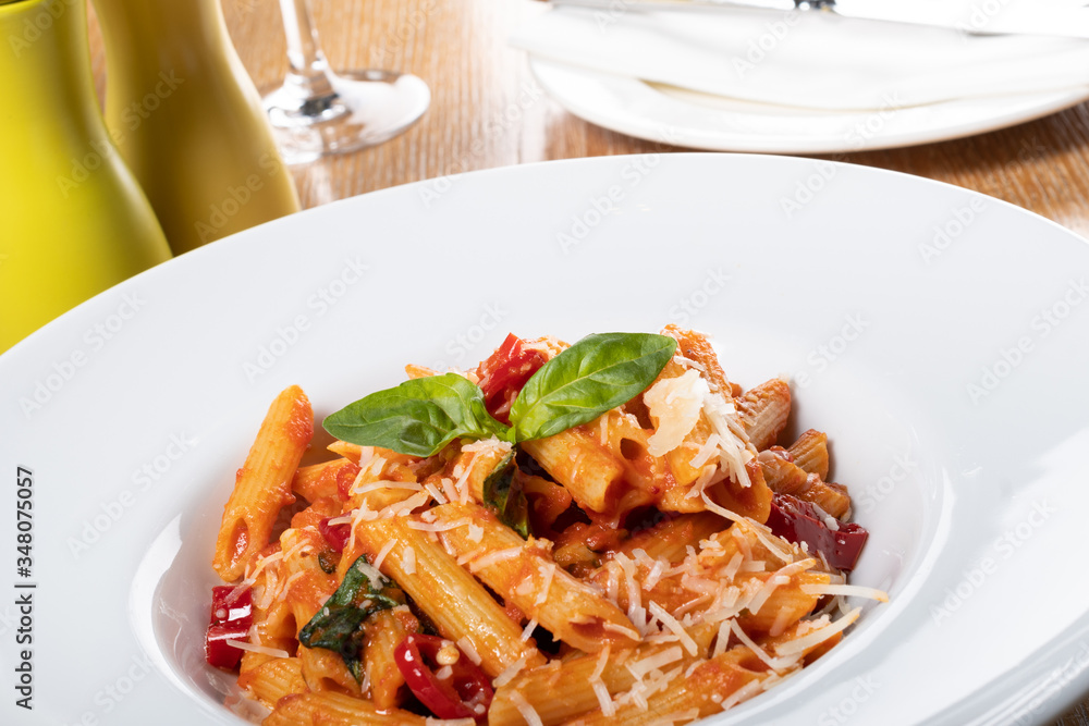 Pasta penne Napoli, traditional italian cuisine dish, chili, tomato and parmesan sauce
