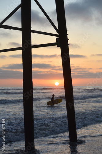 Surfer under the Oceanside Pier at sunset © Rosemary