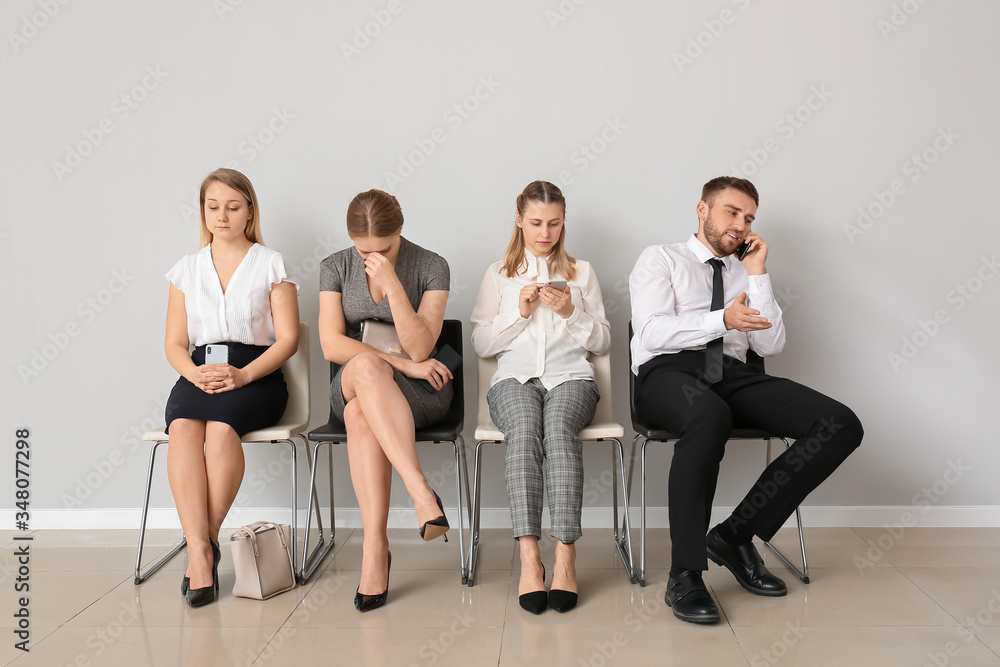Business people waiting in line indoors Business people waiting in line indoors