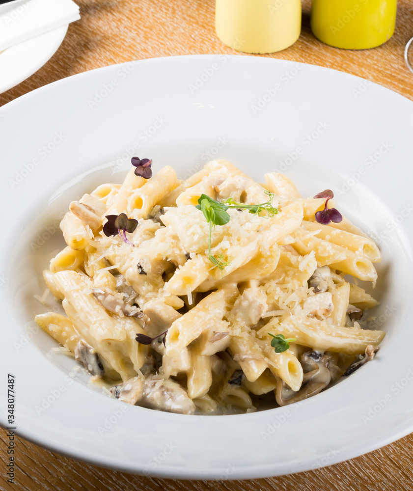 Prepared penne pasta with chicken and forest mushroom sauce, cheese with parmesan and mozzarella