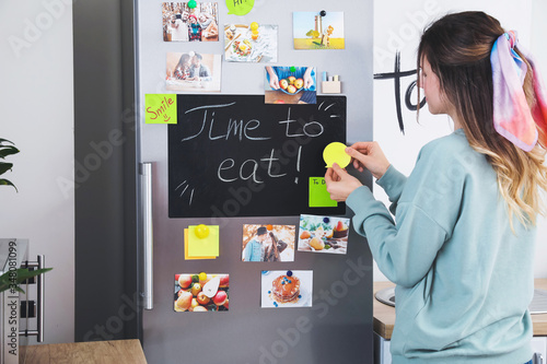 Young woman near refrigerat...