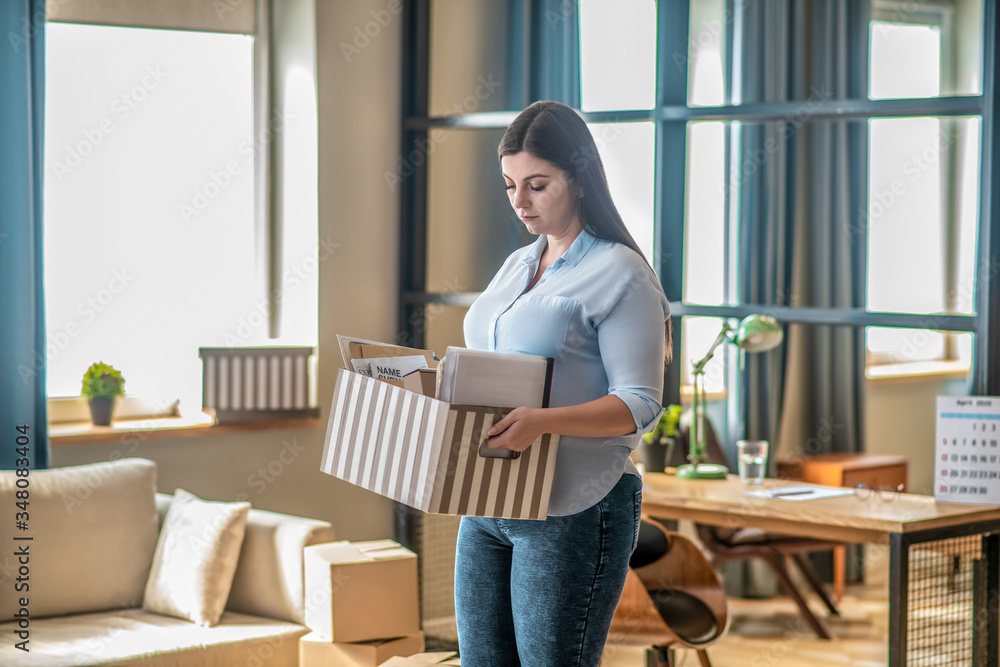 Young woman holding a cardoard and looking sad Young woman holding a cardoard and looking sad