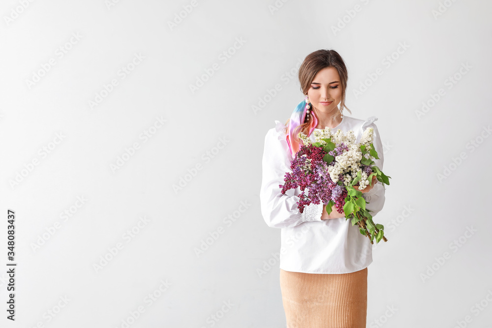 Beautiful young woman with lilac flowers on light background Beautiful young woman with lilac flowers on light background