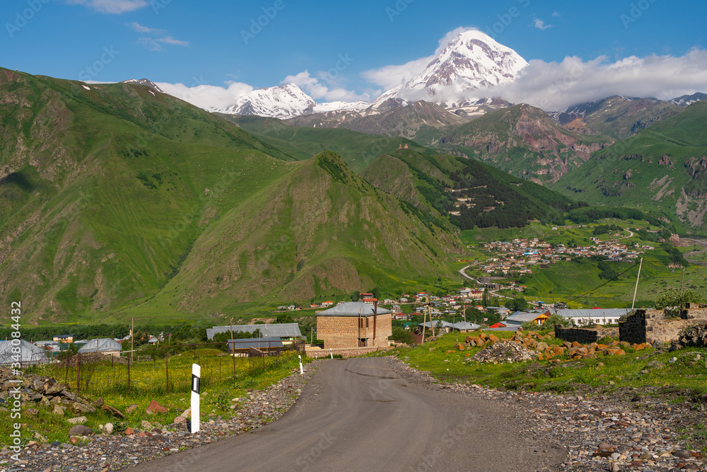 Road to Kazbegi town with Kazbeg mountain peak behind in summer season, Georgia