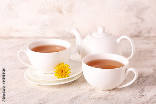 Cups of healthy dandelion tea on light background