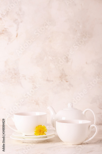 Cups of healthy dandelion tea on light background