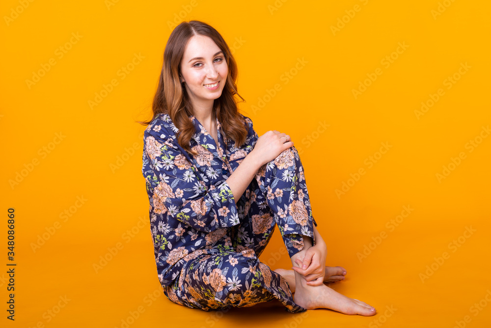 Obraz premium Fashion portrait pretty cool girl having fun over colorful yellow background. Pajama and home clothes concept