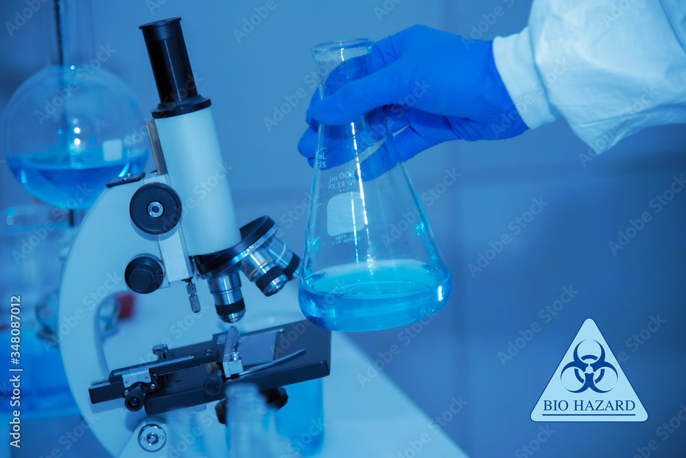 Fototapeta premium Close up of scientist hand holding scientific glassware ,LAB scientific and chemistry background of Covid-19 blood test tube and microscope