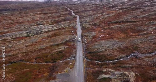 Aerial view of the  Aursjovegen mountain road. Small white van following the narrow road. Rust-colored lichen and moss cover the landscape. photo