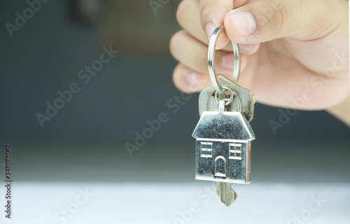 Close up of hand holding a home key in his hand.