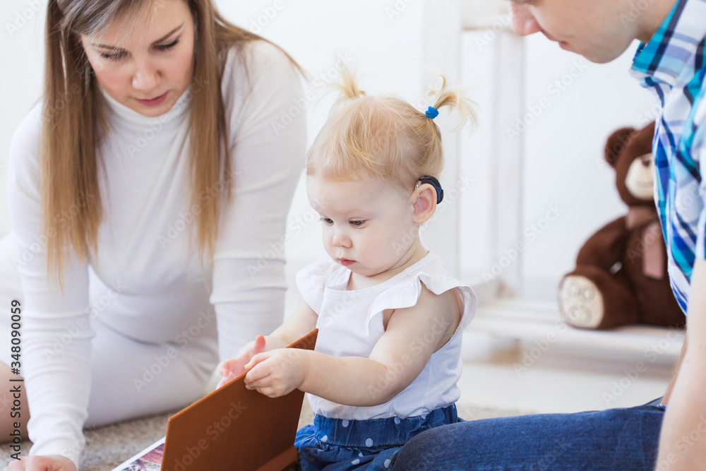 Baby girl wearing a hearing aid. Disabled child, disability and deafness concept. Baby girl wearing a hearing aid. Disabled child, disability and deafness concept.