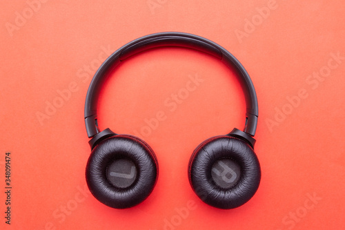 Black headphones. From above . Red background. Copy space