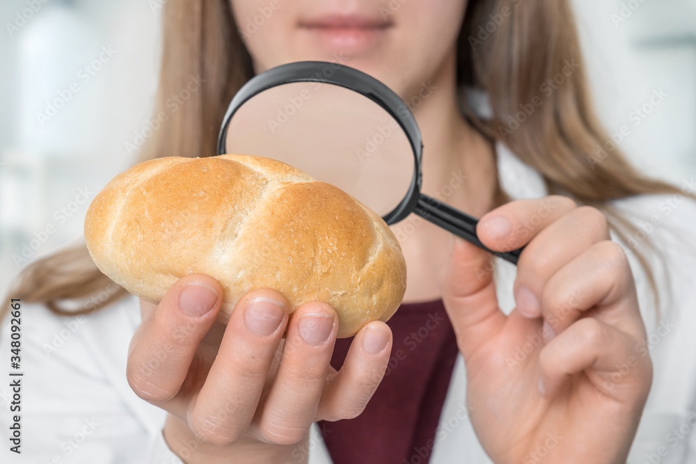 Scientist examines a bun with magnifying glass Scientist examines a bun with magnifying glass