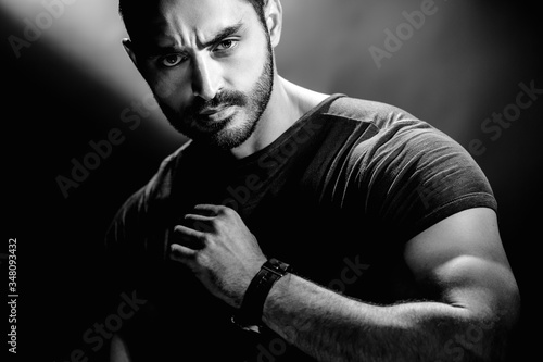 Young bearded man with serious face and brutal style, monochrome portrait