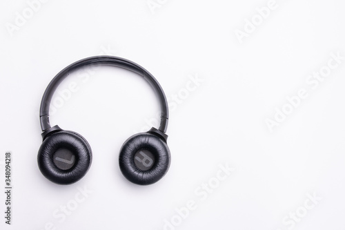 Black headphones on the left side of the photo. From above . White background. Copy space