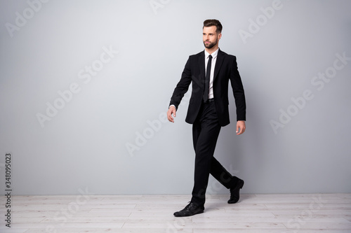 Full size profile side photo of stylish handsome economist worker man go walk to workplace meeting wear trendy pants trousers isolated over grey color background photo