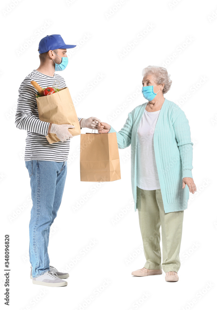 Courier of food delivery company giving products to elderly woman on white background. Concept of epidemic Courier of food delivery company giving products to elderly woman on white background. Concept of epidemic