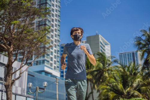 Man runner wearing medical mask. Running in the city against the backdrop of the city. Coronavirus pandemic Covid-19. Sport, Active life in quarantine surgical sterilizing face mask protection