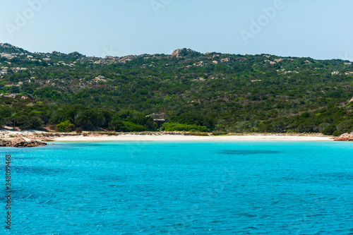 A view from a sailboat of the crystal clear and colorful sea of ​​Budelli island with its famous and protected pink beach on a sunny day, in Budelli island Sardinia Italy 