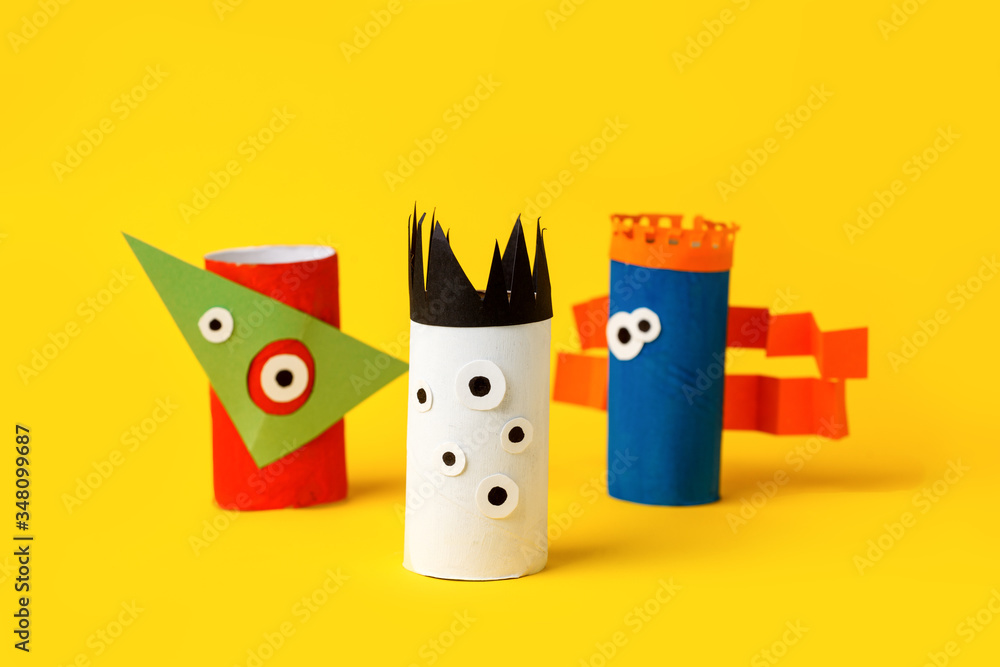 Obraz premium Kids art therapy, coronavirus pandemic. Halloween crafts, paper monsters on blue paper background with copy space for text. Concept handcraft, diy, creative idea from toilet tube, recycle