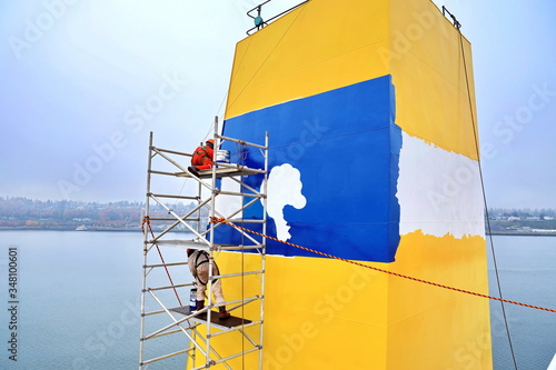 Slika na platnu Repainting the ship’s funnel and drawing the logo of the shipowner with members of the ship’s crew