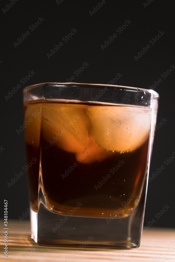 Glass of whiskey on wooden background close up Glass of whiskey on wooden background close up