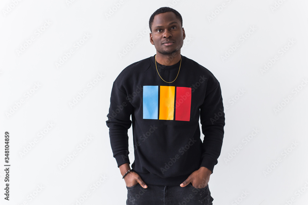 Fototapeta premium Street fashion concept - Studio shot of young handsome African man wearing sweatshirt against white background.