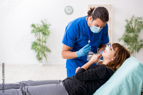 Young beautiful woman visiting doctor in plastic surgery concept