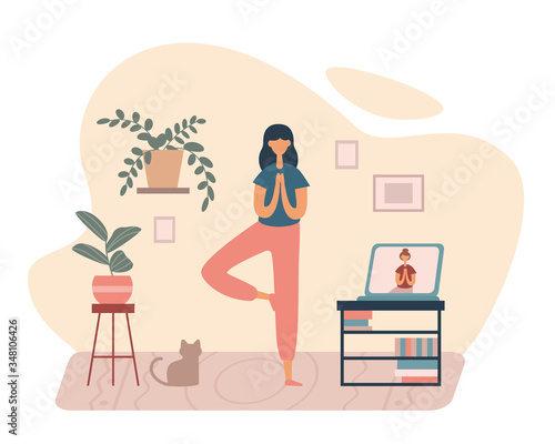 Woman doing yoga with online tutorial at home